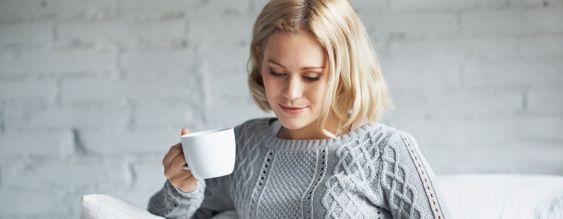 woman on couch with a cup of coffee
